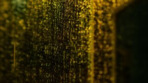 Golden droplets of light scattered across a dark window at night